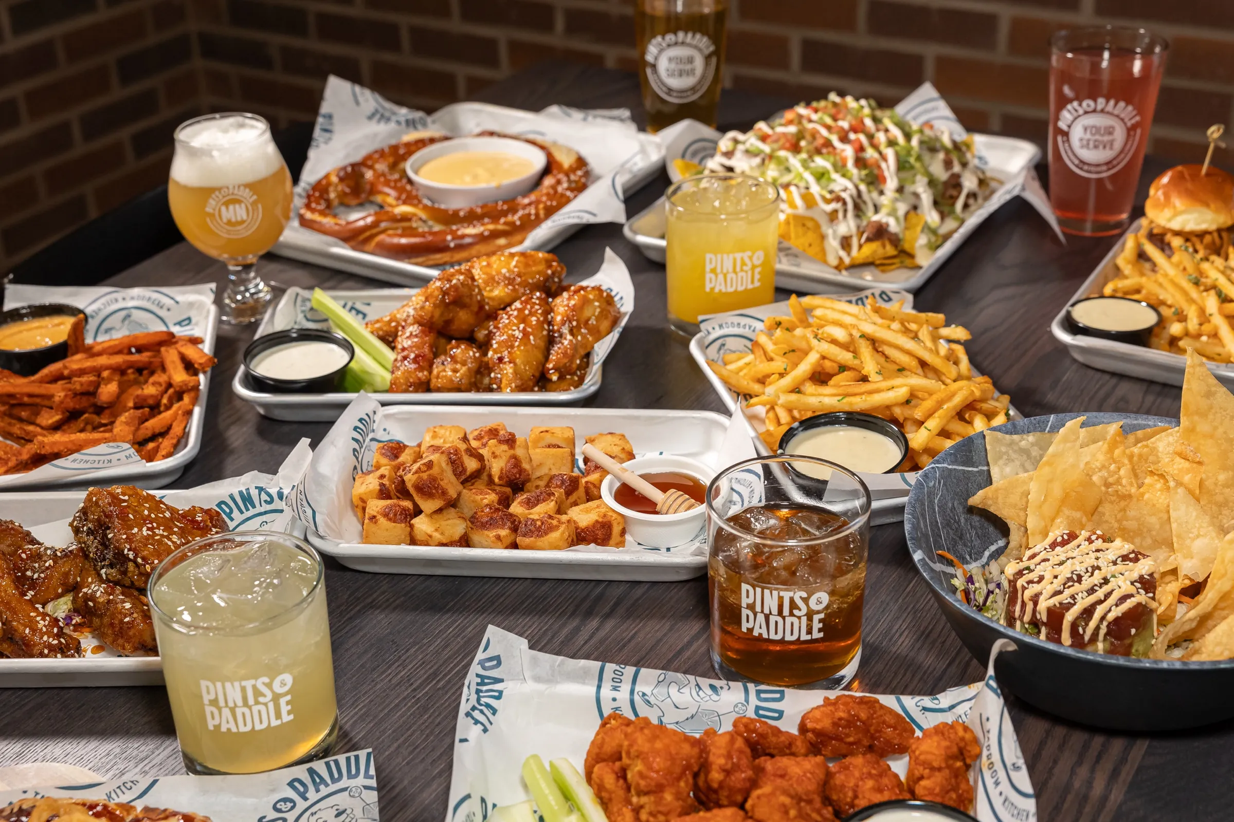 A full spread of Pints & Paddle appetizers and drinks