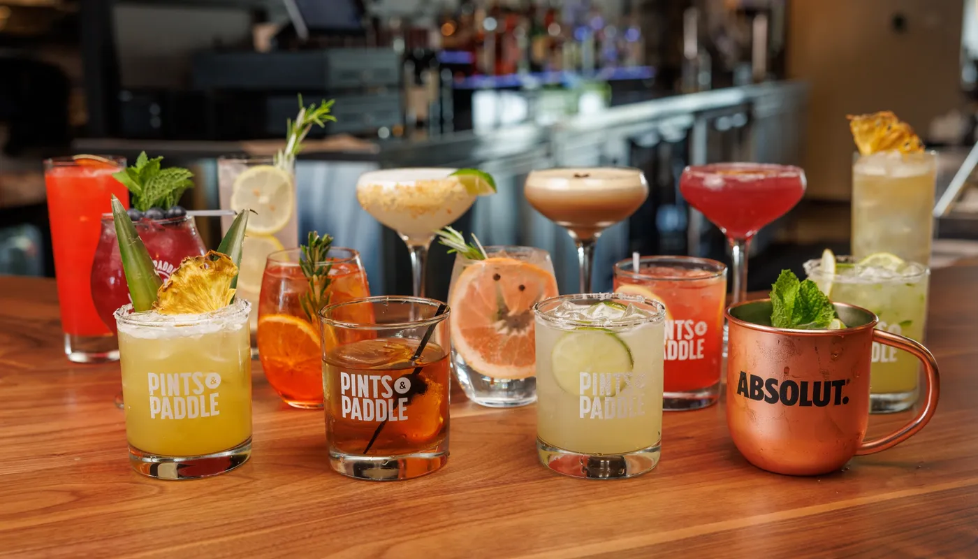 A lineup of scratch cocktails on the bar: margaritas, martinis, a mule and an old fashioned