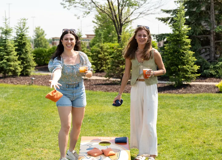 Two friends tossing bags on the patio lawn