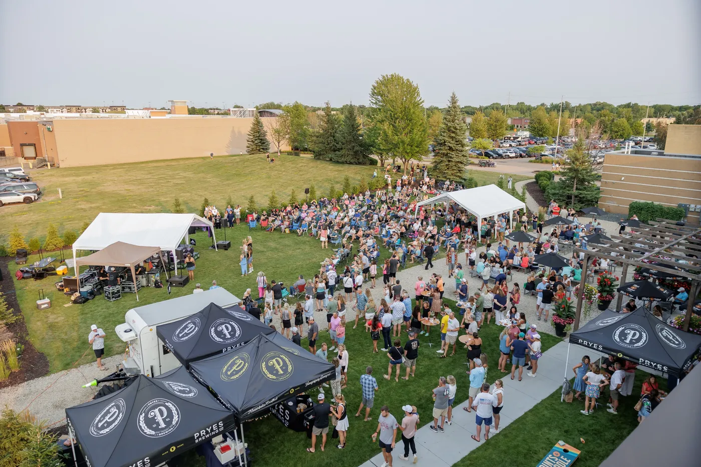 Aerial view of the patio lawn packed for a Slam & Jam concert, with stage tents and the crowd across the grass