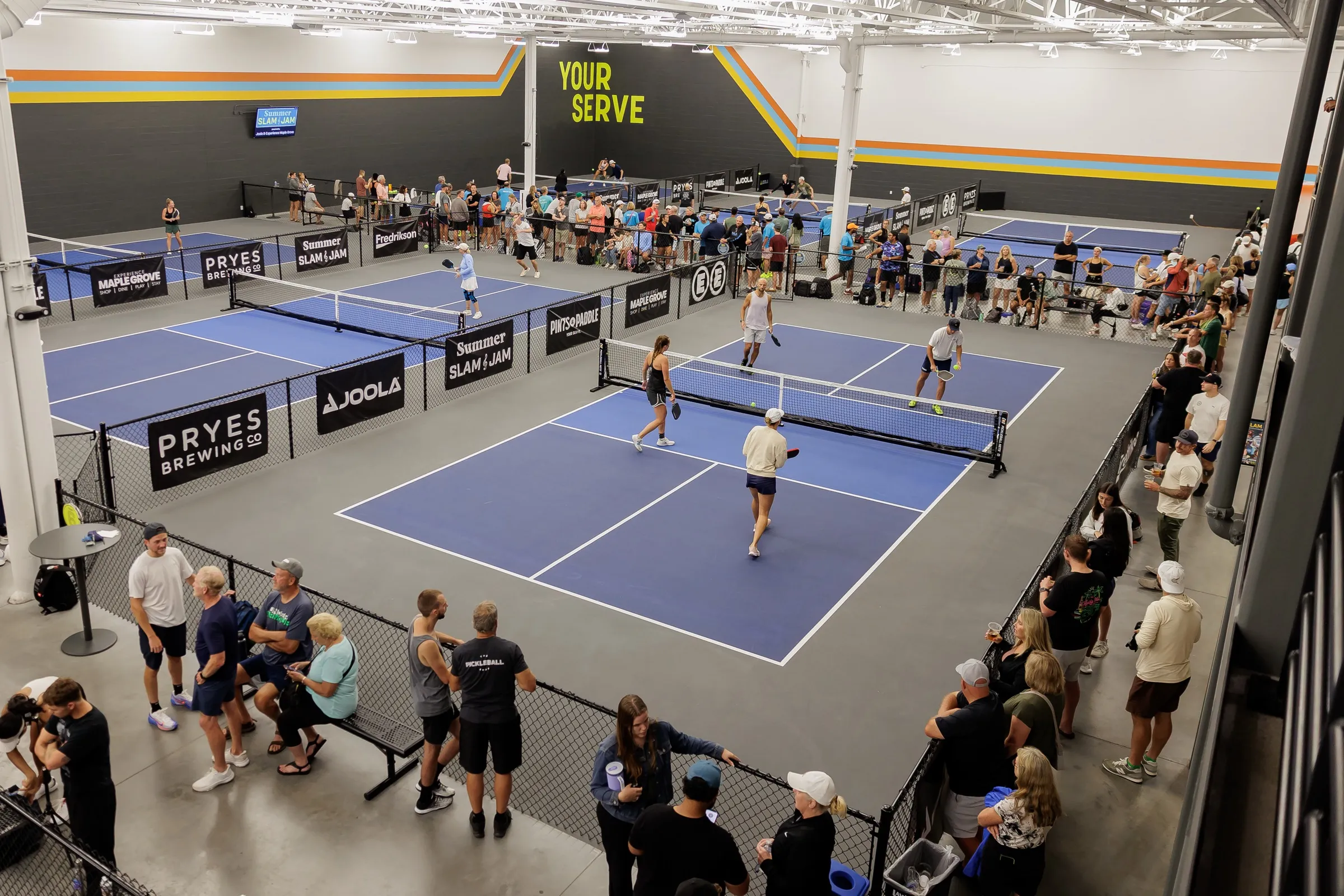 Elevated view of the indoor courts with several matches in play