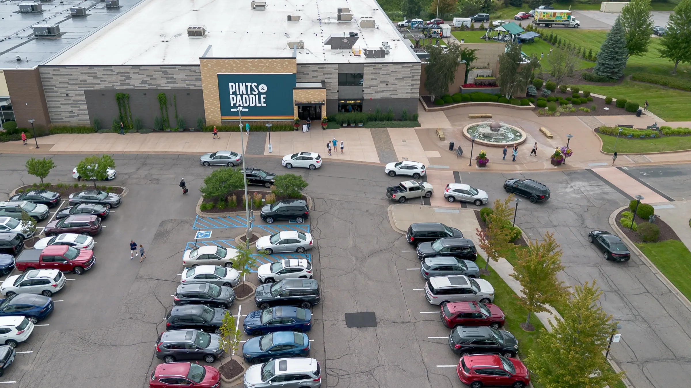 Aerial view of the building entrance, the plaza fountain and the parking lot