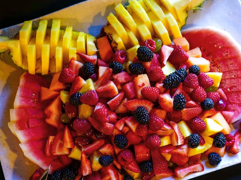 A fruit platter with pineapple, watermelon, berries, grapes and cantaloupe