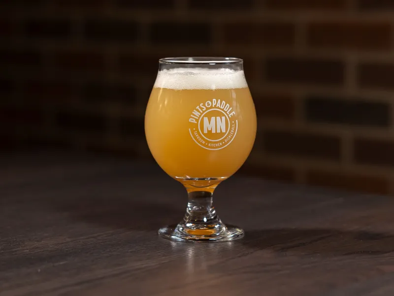 A hazy IPA with a thick foam head in a Pints & Paddle tulip glass
