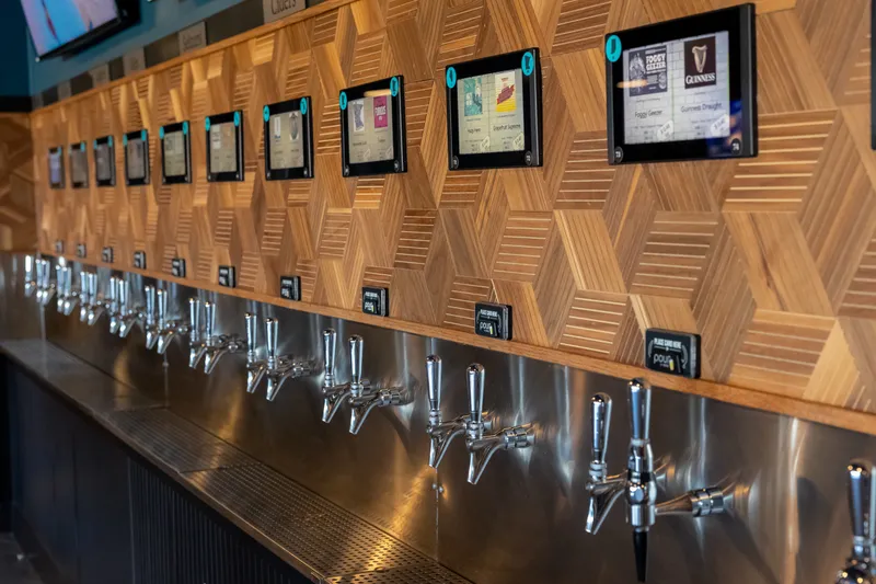The mezzanine self-serve tap wall with tap handles, label screens and card readers