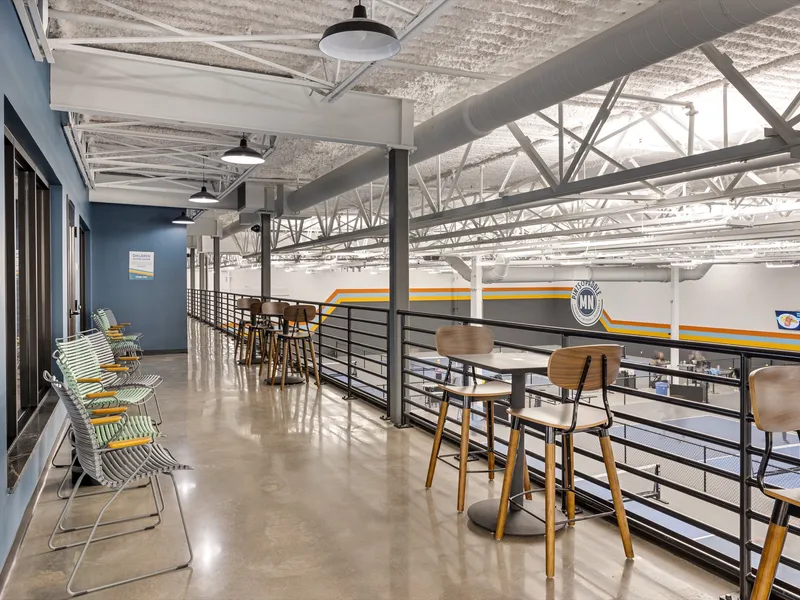 The mezzanine walkway with drink-rail seating overlooking the indoor courts