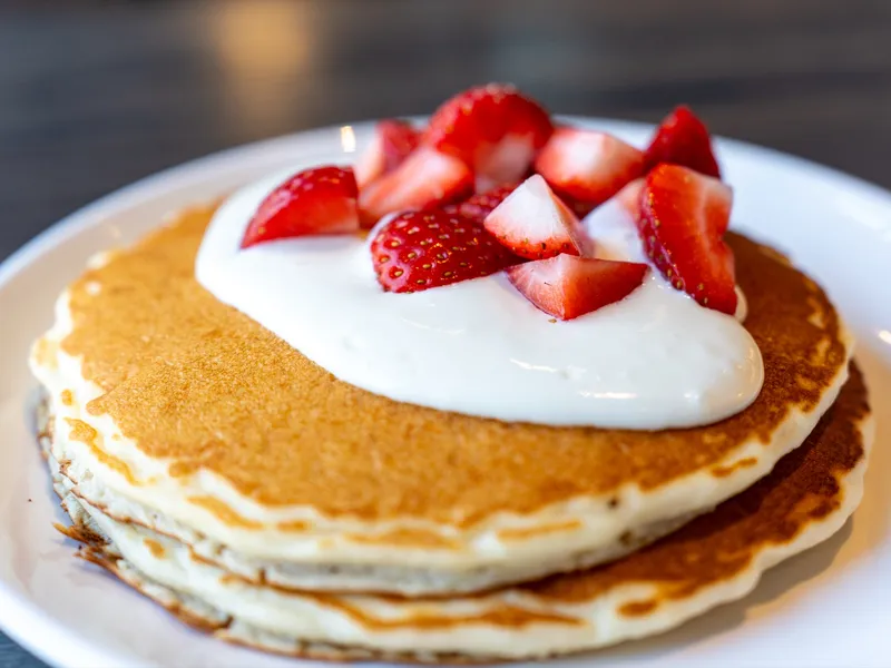 Close-up of pancakes with whipped cream cheese and strawberries