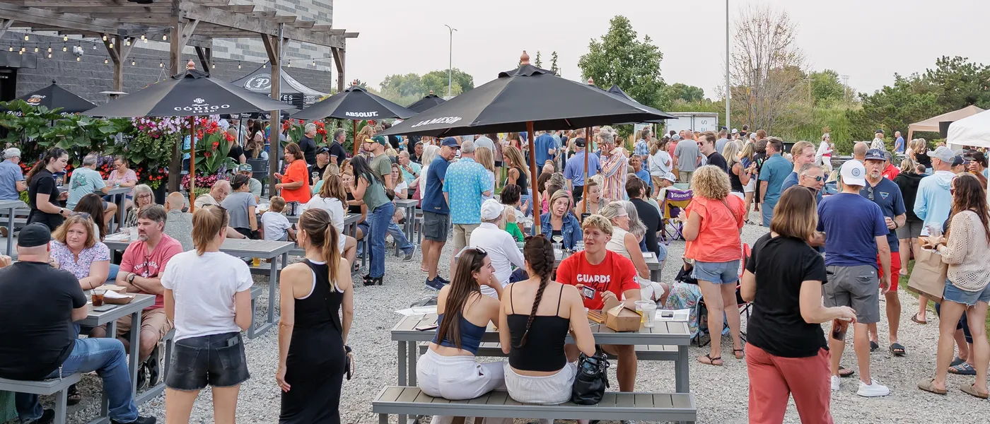 A busy evening on the gravel patio under the pergola string lights