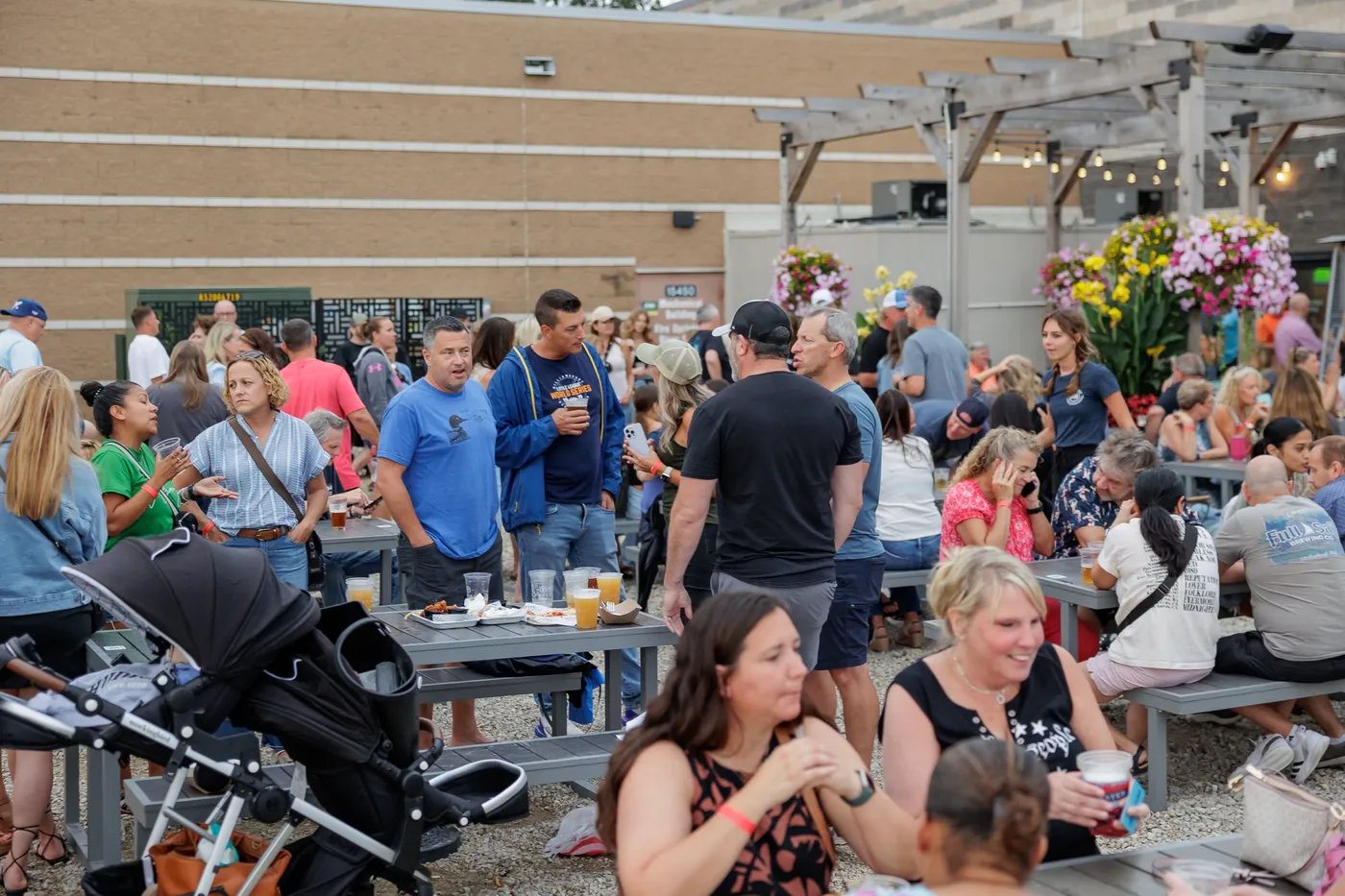 Families and friends gathered at picnic tables on the patio