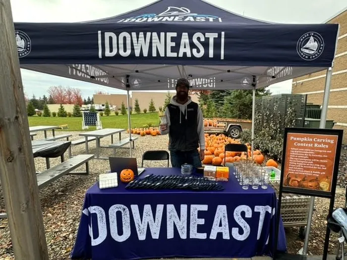 The Downeast Cider tent and table set up on the patio for sampling