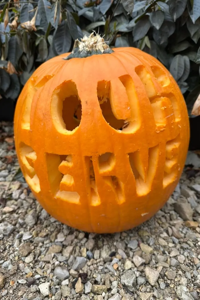 A pumpkin carved with the words YOUR SERVE